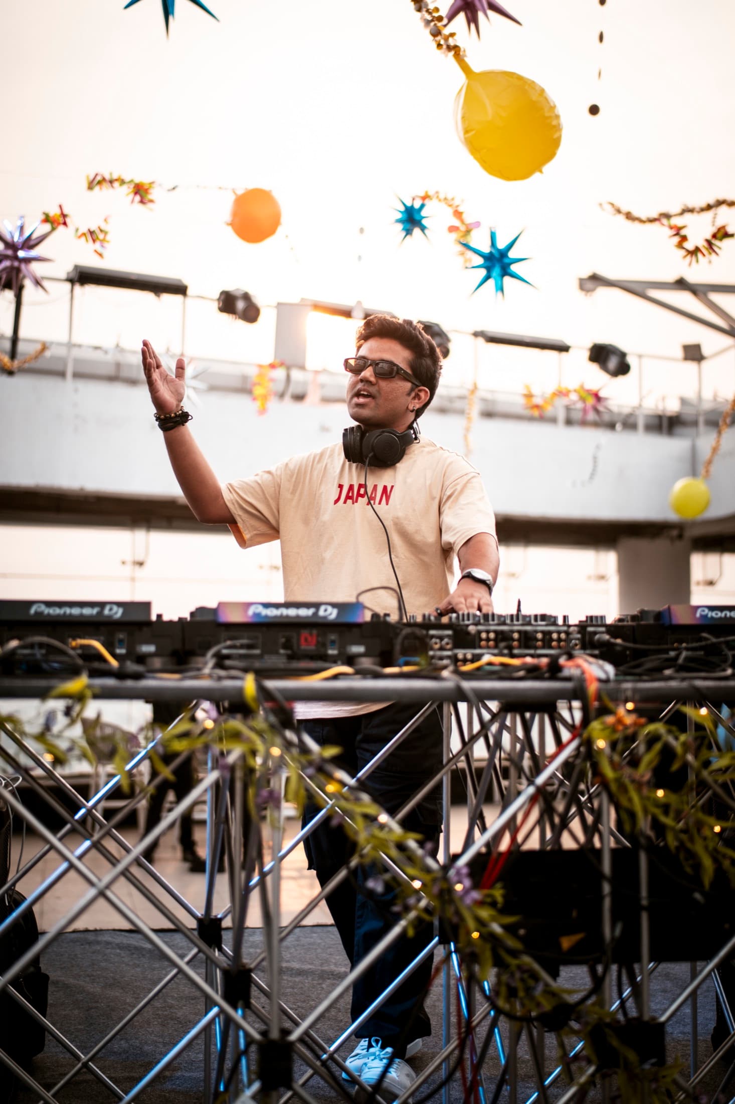 TRE with a hand raised behind the decks